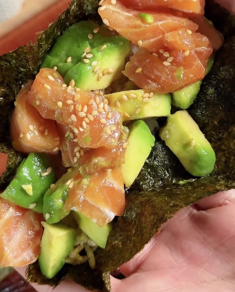 A circular piece of sushi nori being cut from a larger sheet.