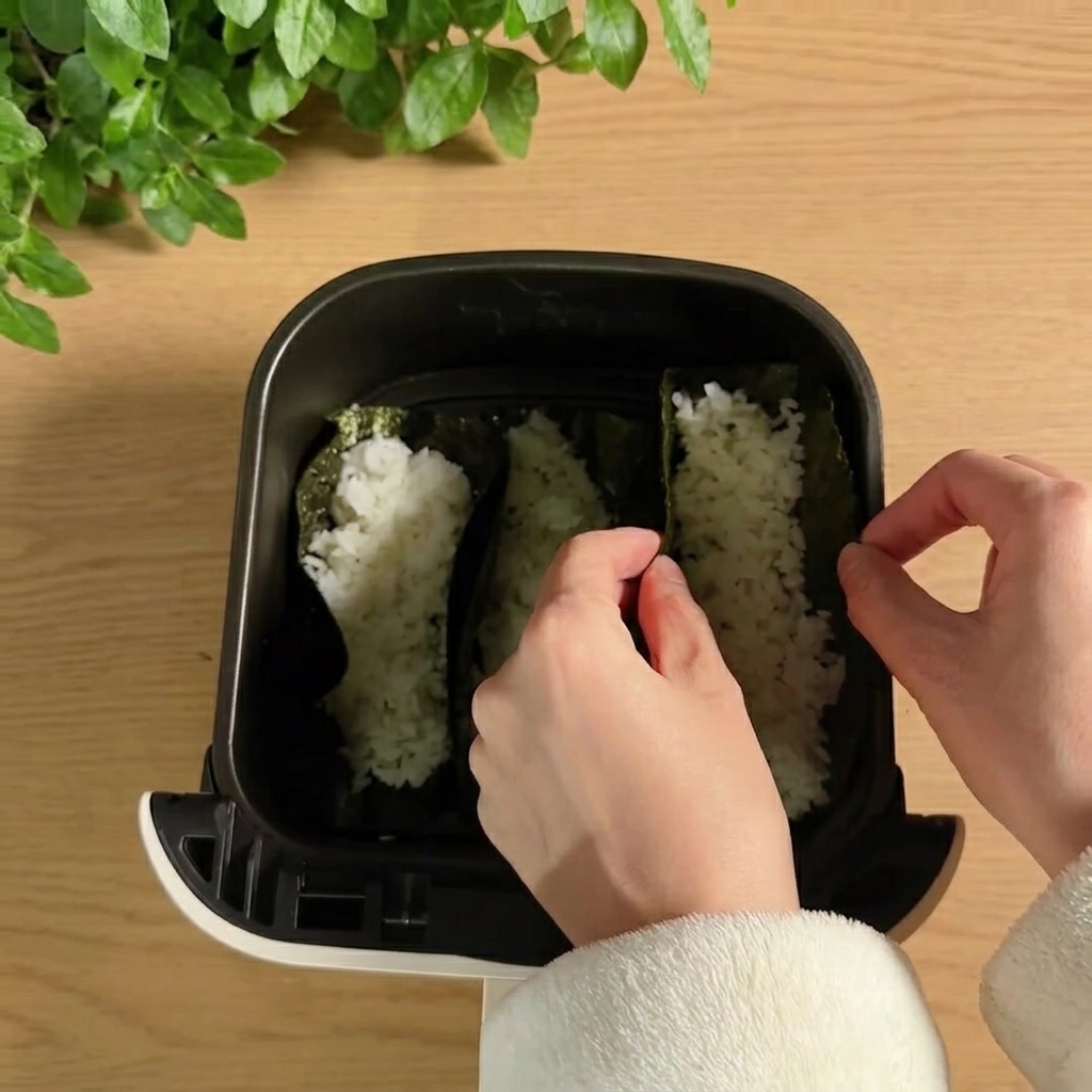 Sushi taco shells standing upright inside an air fryer basket.