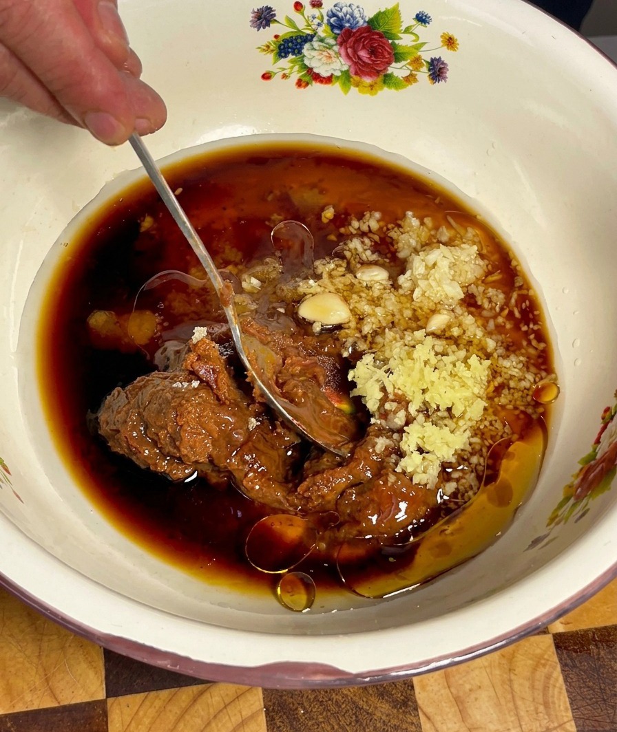 The Doenjang marinade being mixed with a spoon until smooth and well-incorporated.