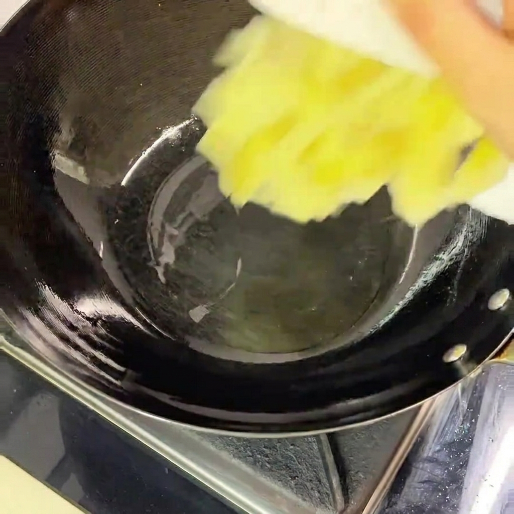 Pouring chopped pickled cabbage from a white plate into a heated black wok containing a shallow pool of oil.