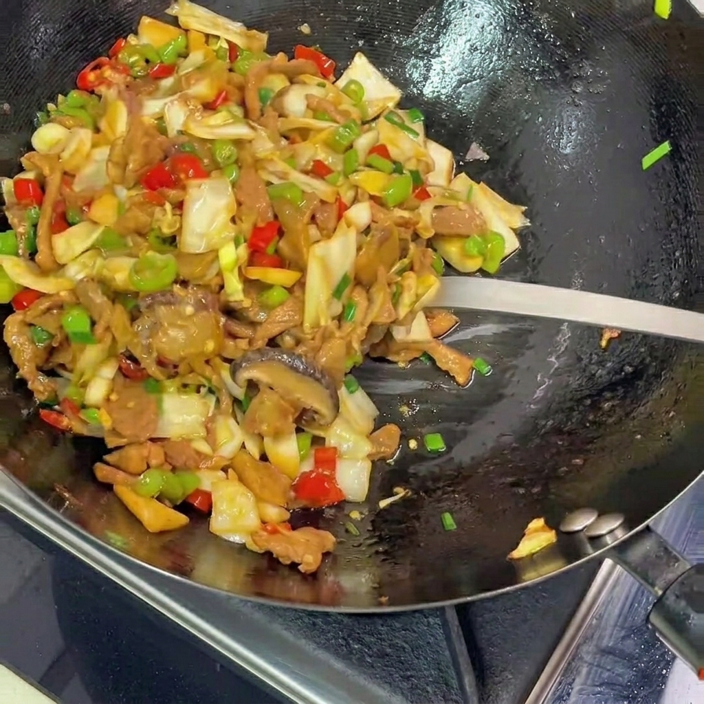 A metal spatula scooping a colorful mixture of stir-fried pickled cabbage, pork, and peppers from a black wok onto a plate.