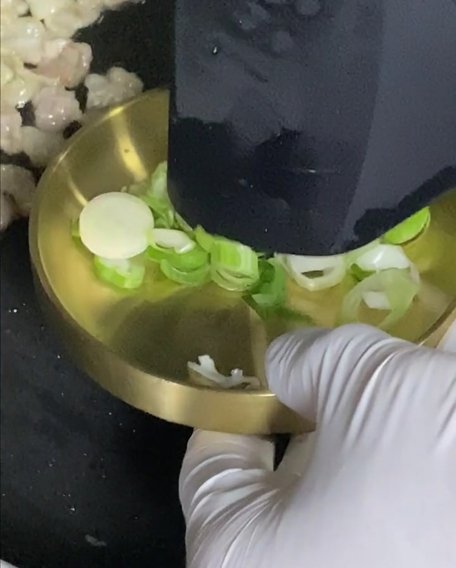 Green onions cooking in the pan alongside the pork belly.