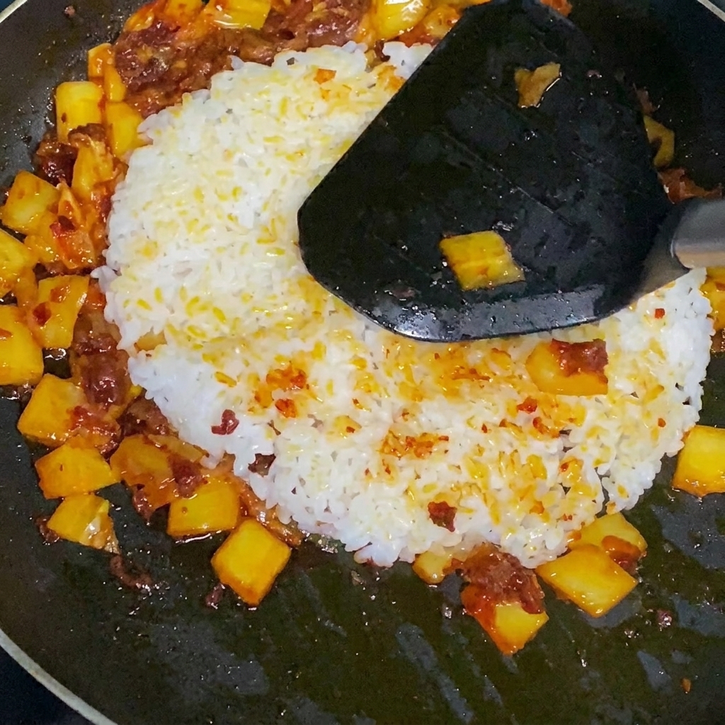Finished kimchi fried rice being stirred in the pan.