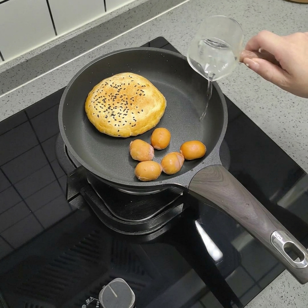 Small sausages placed in a pan with a burger bun, with a clear measuring cup pouring a small amount of water over them.