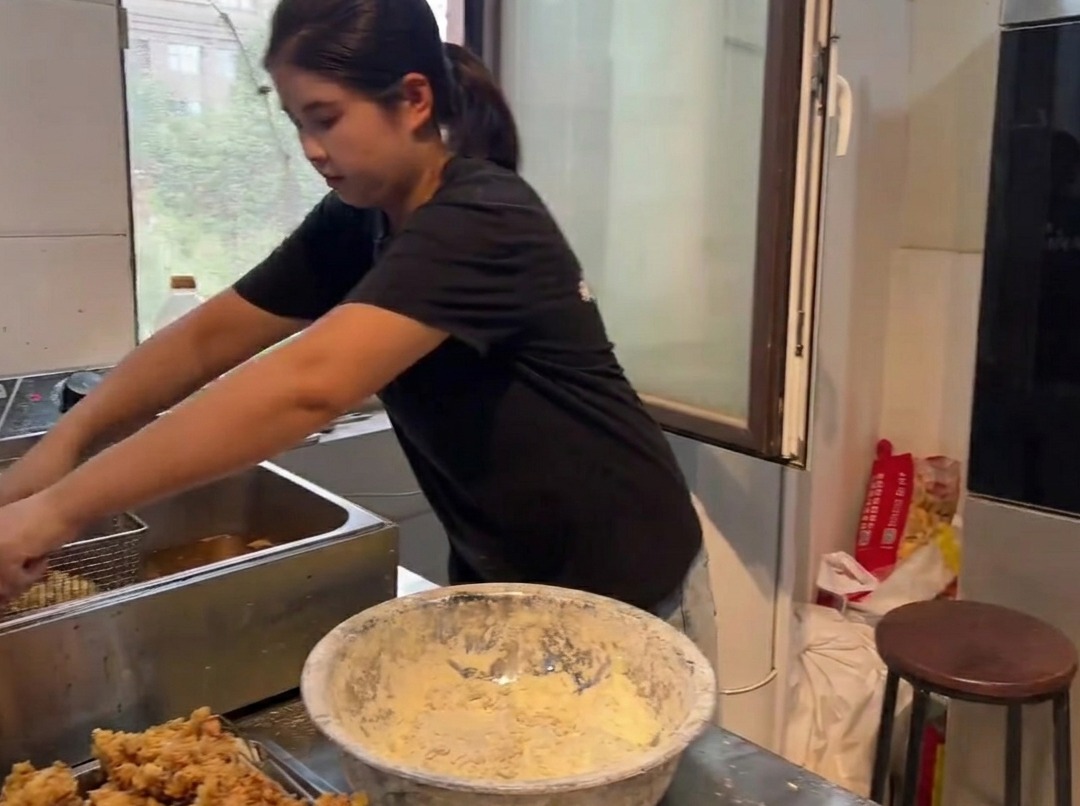 Golden brown, crispy fried chicken pieces being lifted from a deep fryer.
