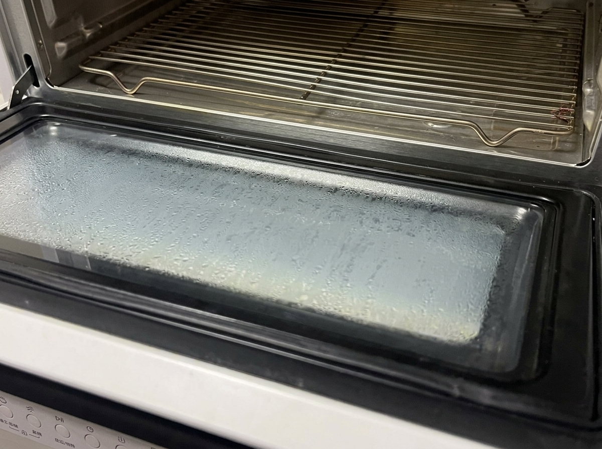 A tray of foil-sealed marinated ribs being placed into an oven.