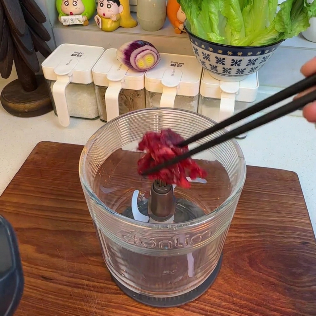 Minced hanger steak inside a food processor container after grinding.