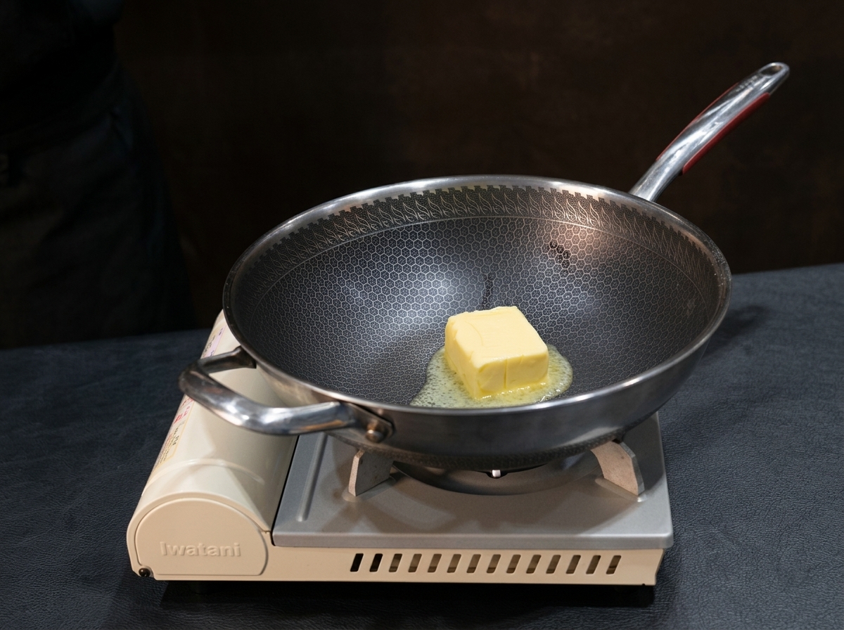 Butter melting in a pan with flour being whisked in to form a smooth roux.