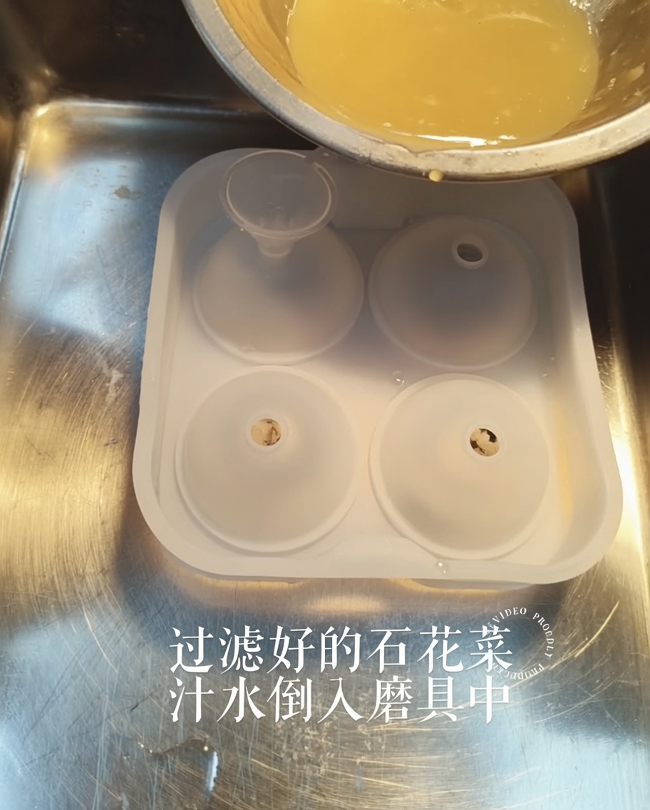 A golden liquid being poured from a small bowl into a silicone mold through a funnel.
