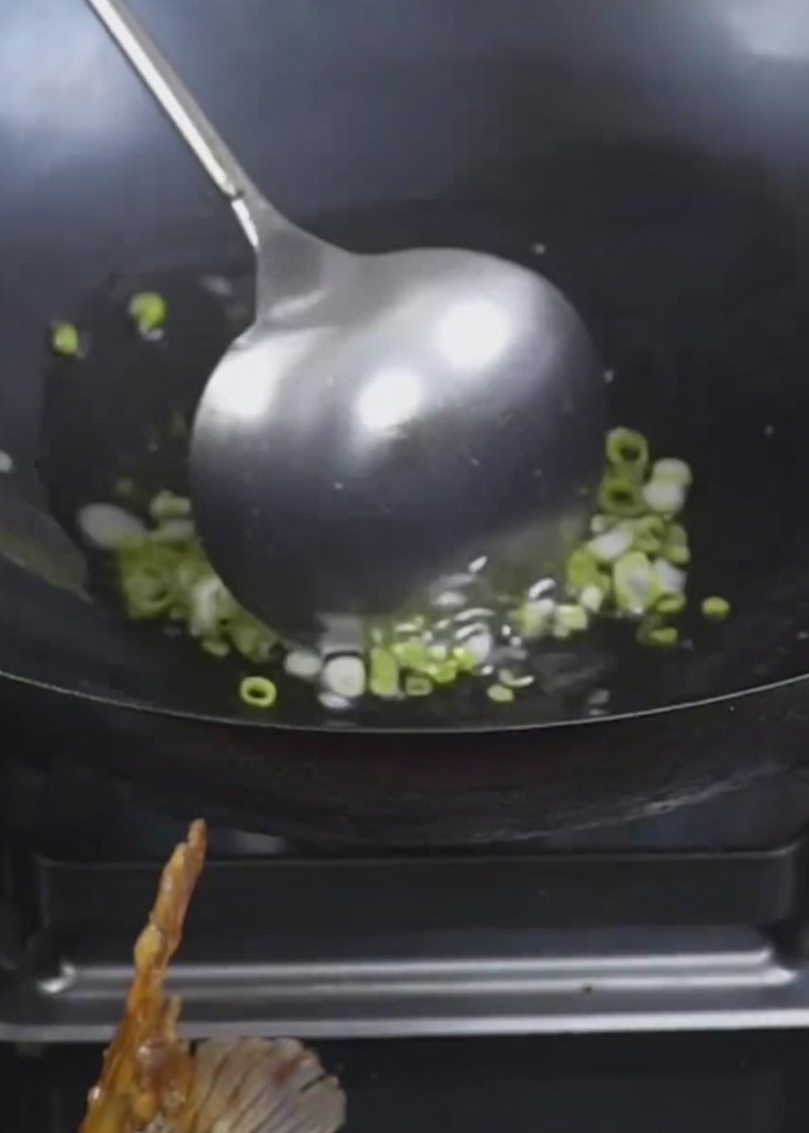 Green onions frying in hot oil until they reach a golden brown color.