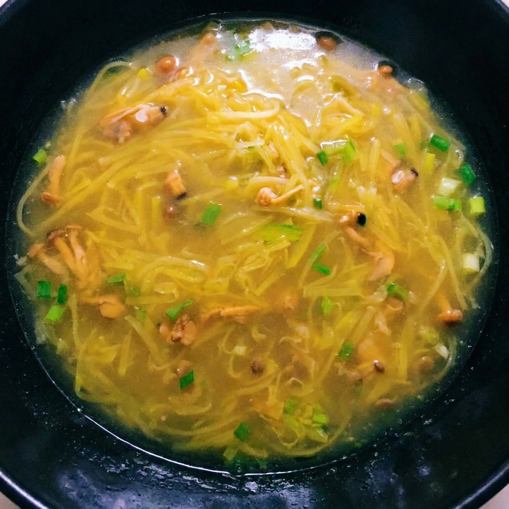 A rich, boiling potato soup with clam meat added, ready for final seasoning.