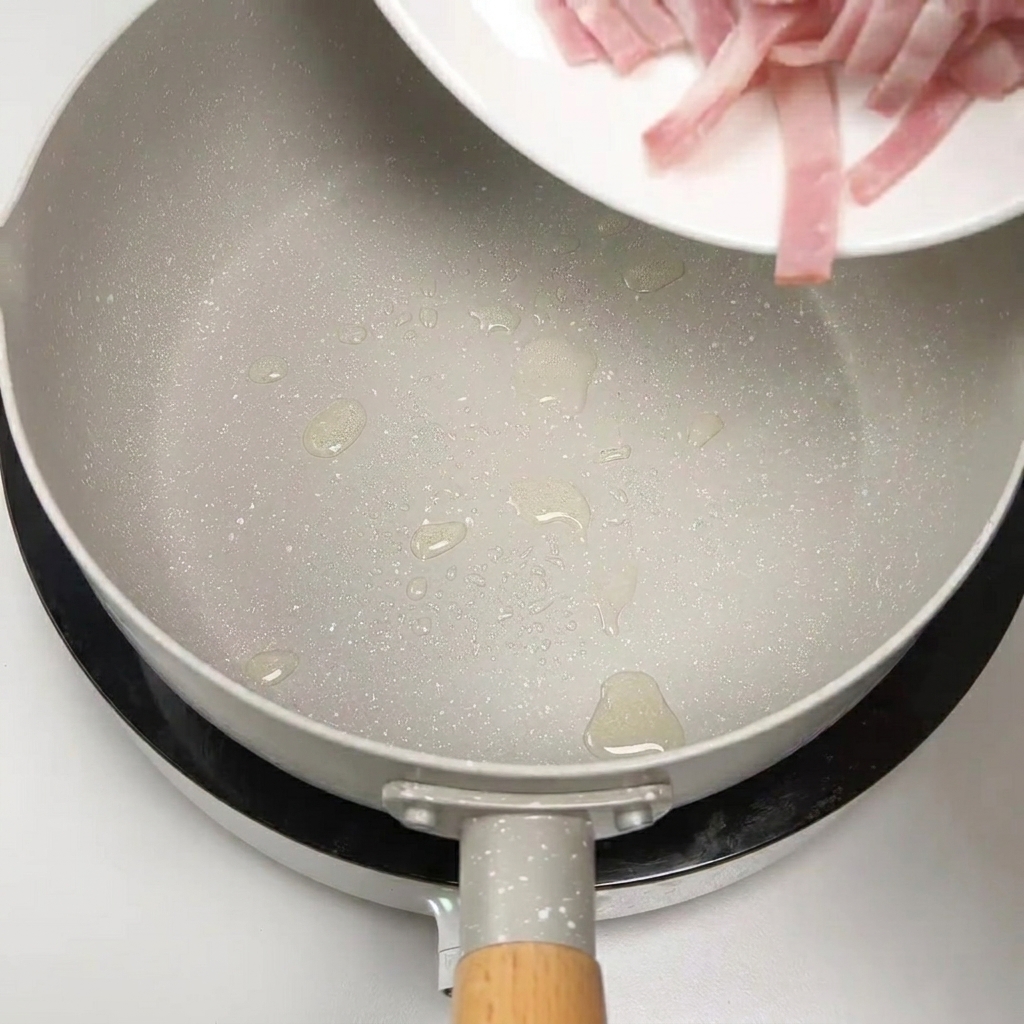 Raw bacon strips being added to a pan to be sautéed.