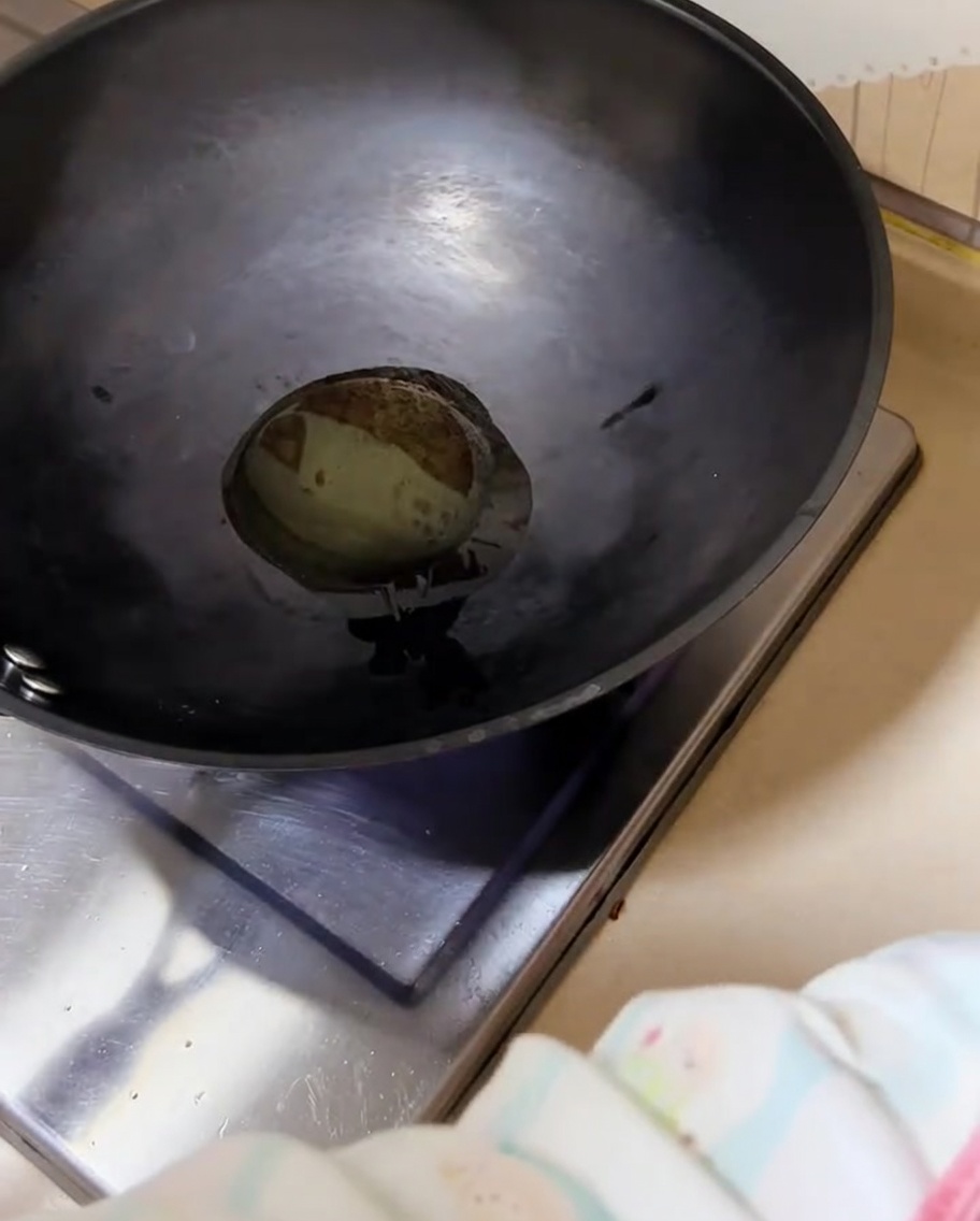 Chopped green onions sizzling in a hot wok with oil.