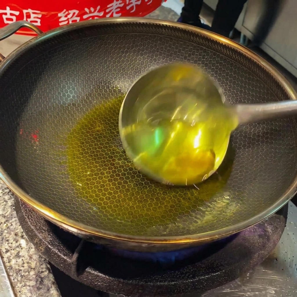 Ginger slices and garlic cloves sizzling in hot oil inside a wok.