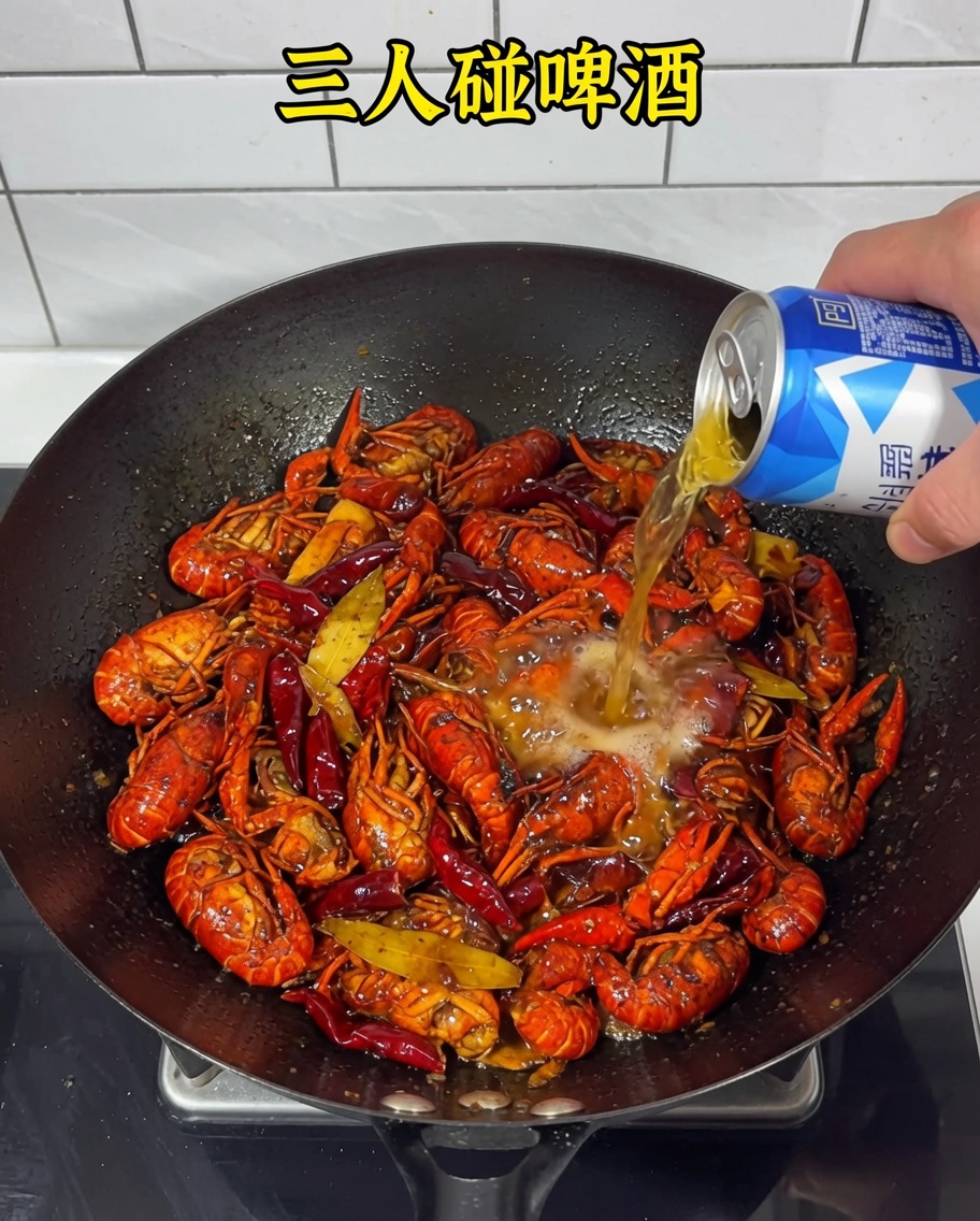 Beer being poured into the wok over the crayfish and spicy base.