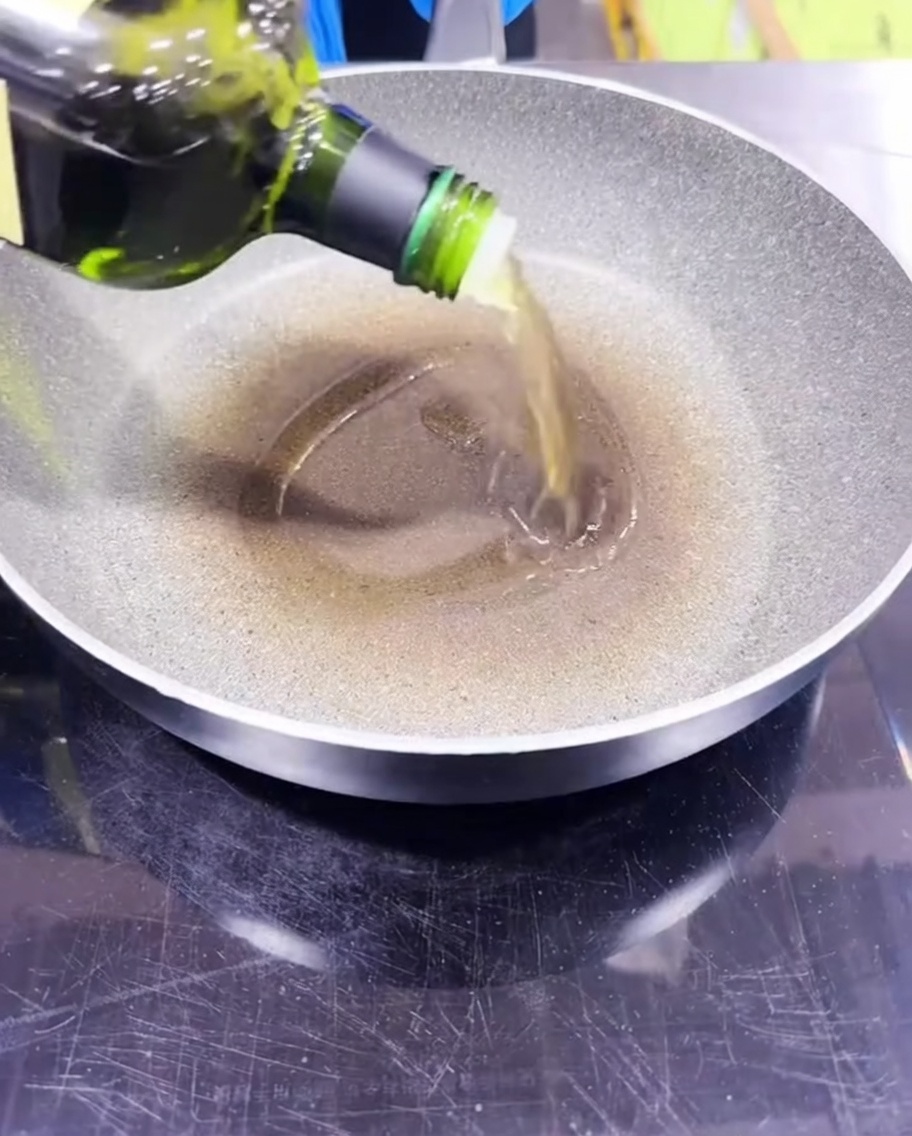 Avocado oil being poured into a preheated frying pan.