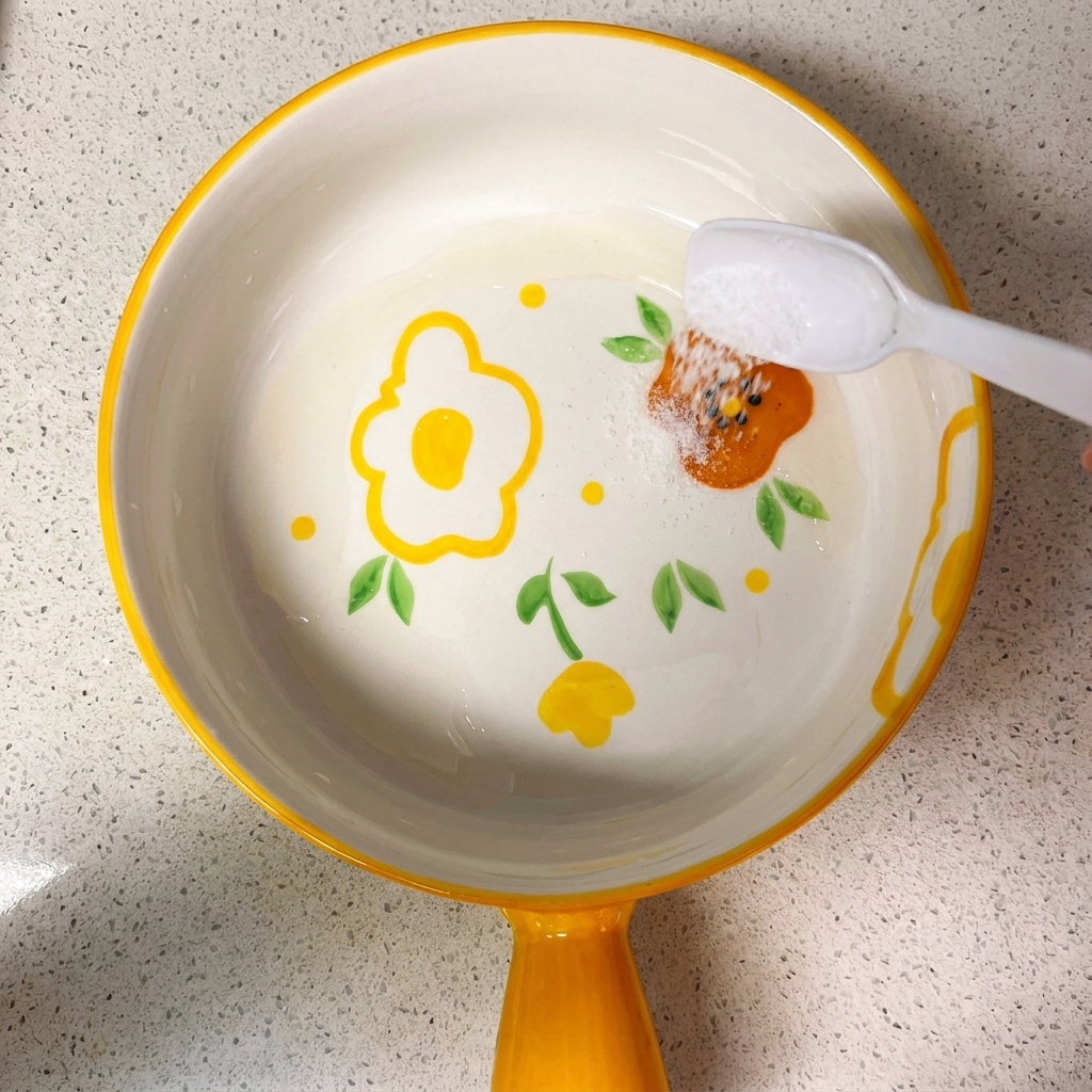 A small bowl containing a mixture of soy sauces, sugar, salt, cornstarch, and water, being stirred with a spoon.