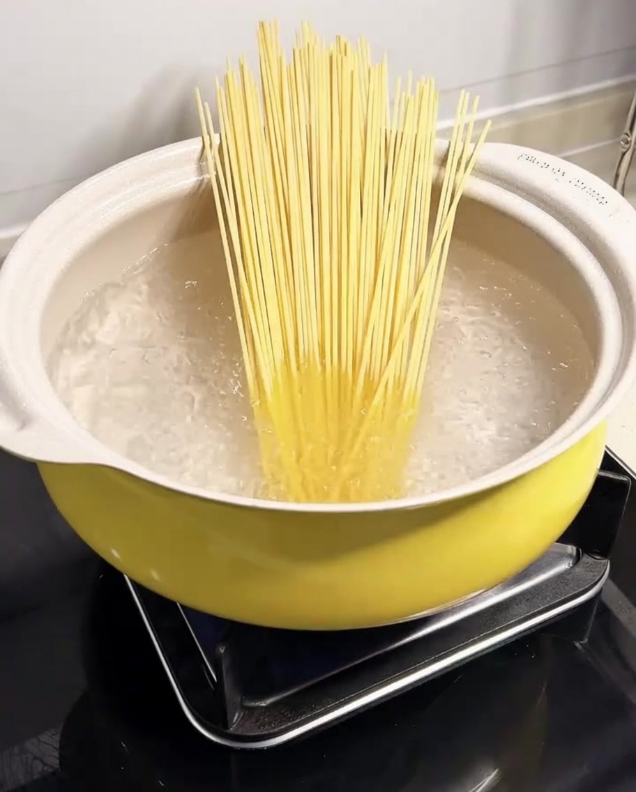 Spaghetti pasta submerged in a pot of boiling water.