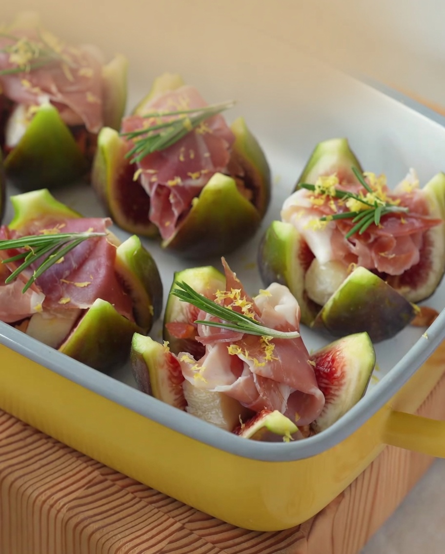 A close-up view of honey being drizzled over figs stuffed with Brie and ham.