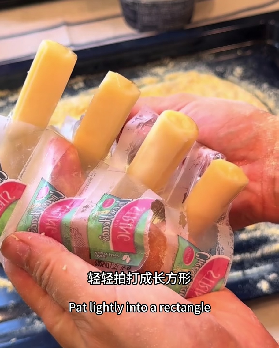 Mozzarella cheese sticks positioned along the perimeter of the rectangular pizza dough.