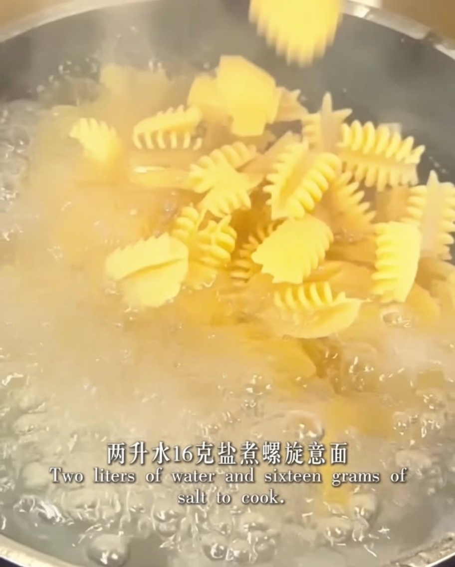 Spiral pasta cooking in a pot of boiling salted water.