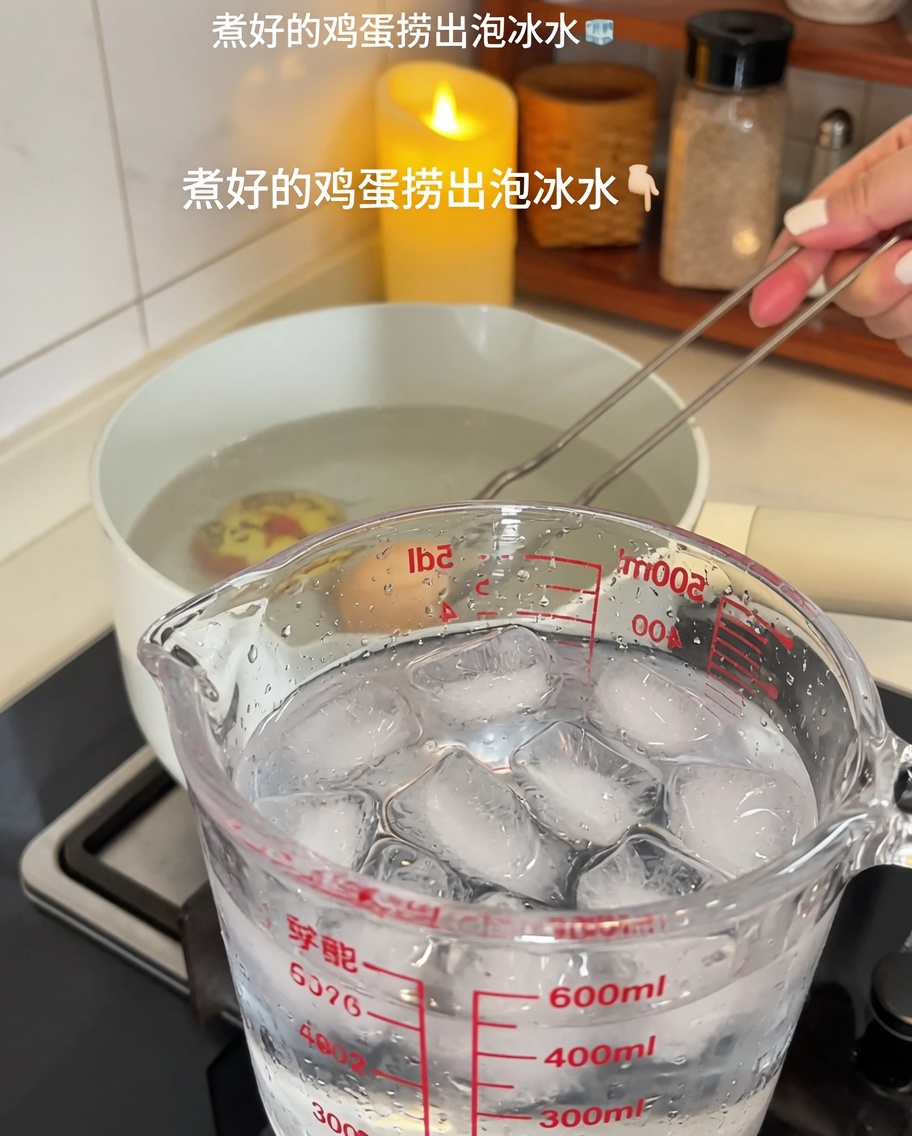 Boiled eggs being transferred from a pot into a glass measuring cup filled with ice and cold water.