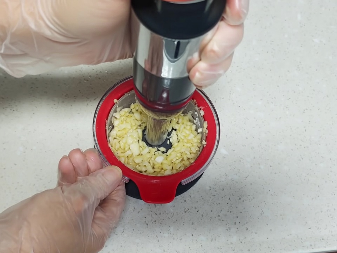 A stainless steel container holding boiled eggs, aromatics, and a soy-based marinade.
