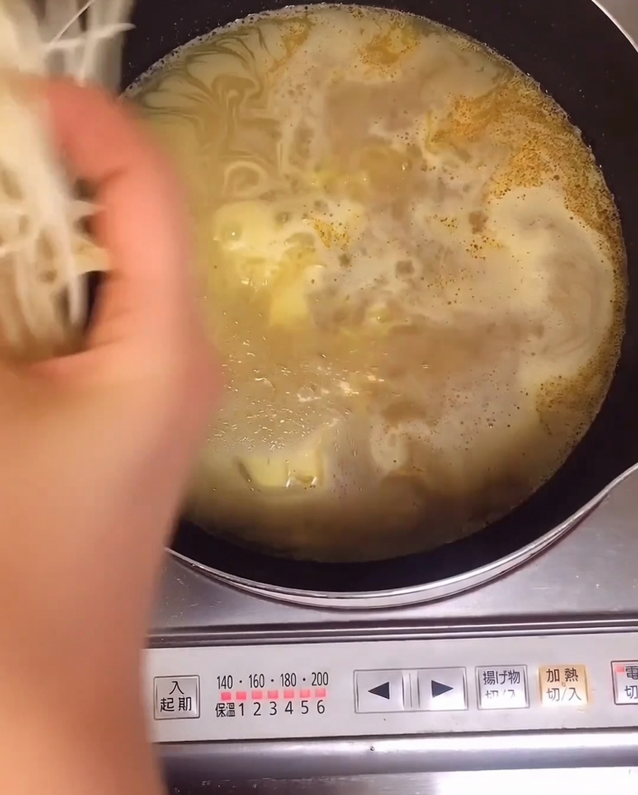 Fresh bean sprouts being added into the pot containing the boiling ramen noodles.