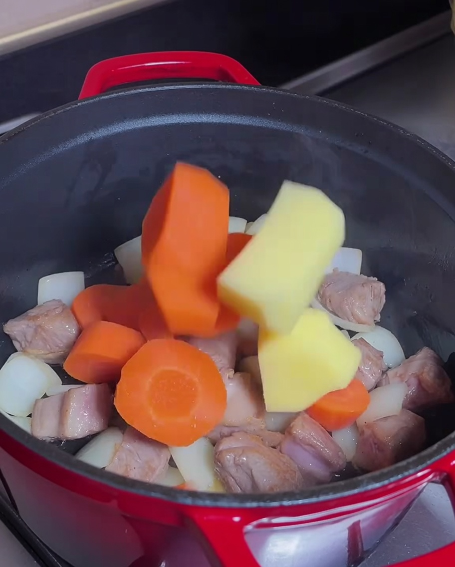Carrots and potatoes mixed into the pot with browned beef.