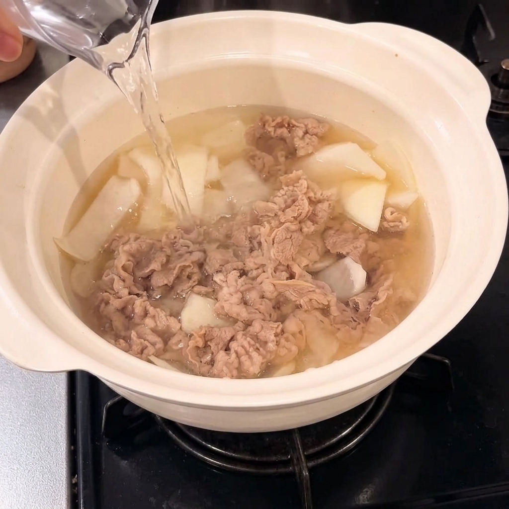 Water being poured into the pot with the beef and onion mixture.