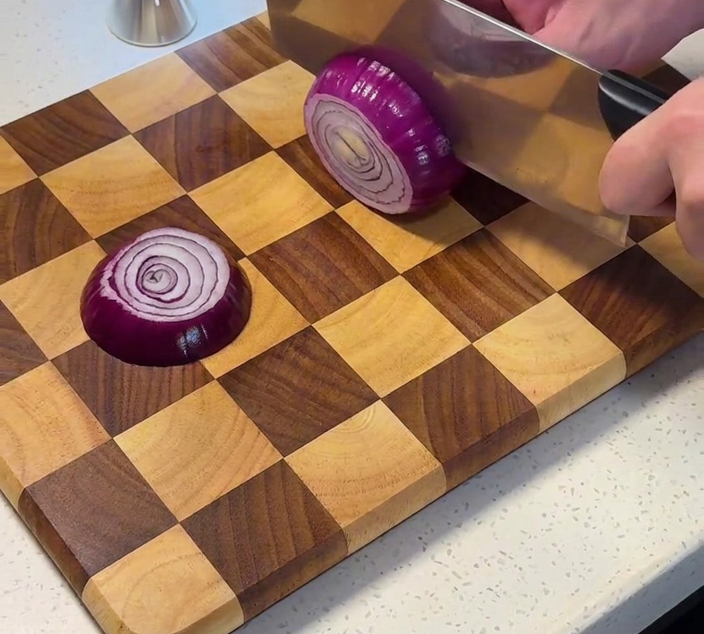 Red onion being diced on a wooden cutting board.