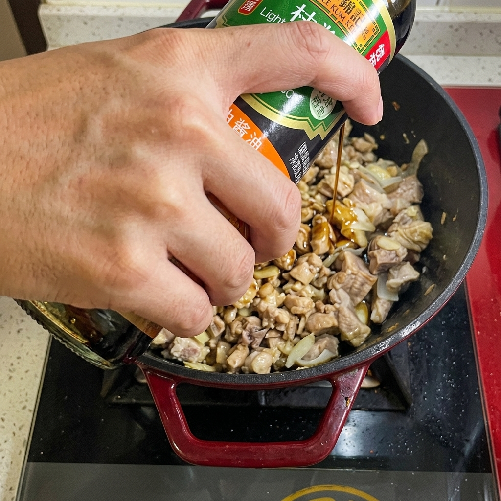 Soy sauce being poured from a bottle into the beef pan.