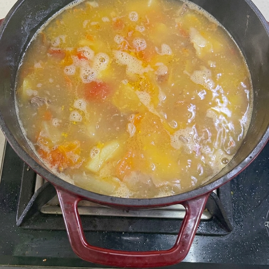 Boiling water being poured into the pot with beef and vegetables.
