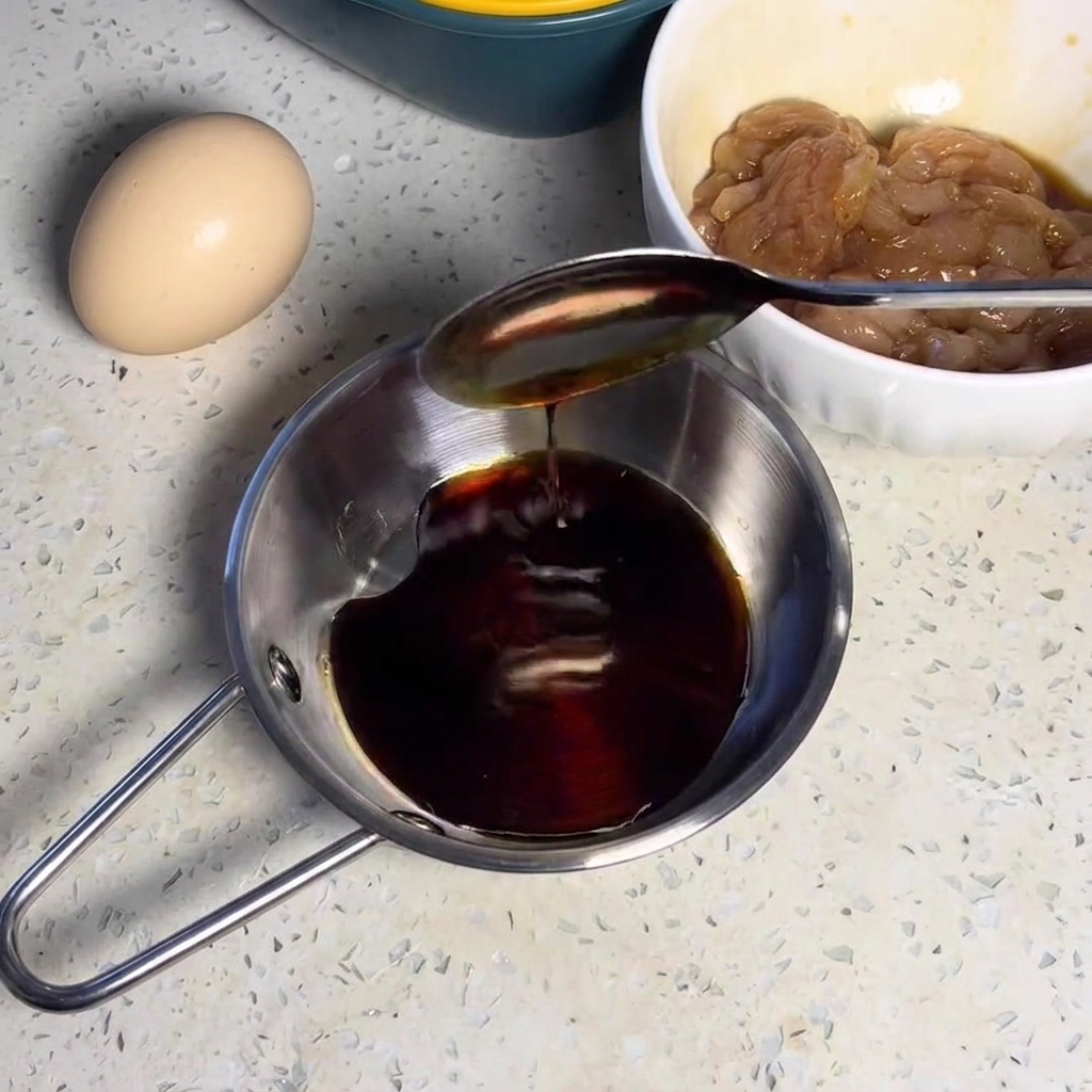 Dark sauce mixture being stirred in a small metal bowl.