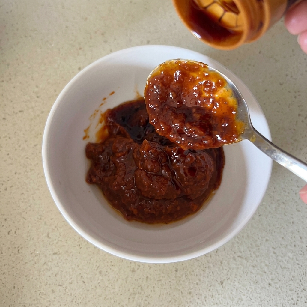 A close-up of the sauce ingredients being stirred together in a bowl.