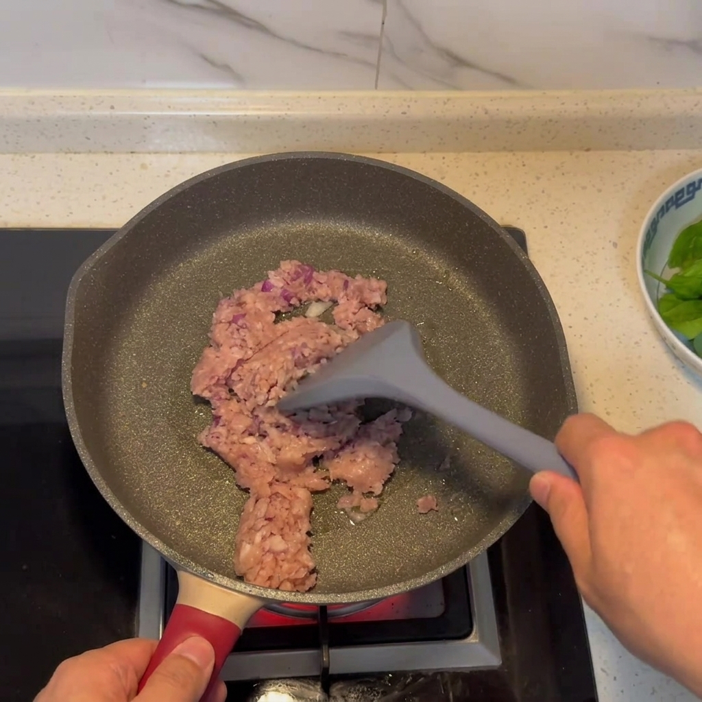 Minced meat and onion mixture browning in a pan.