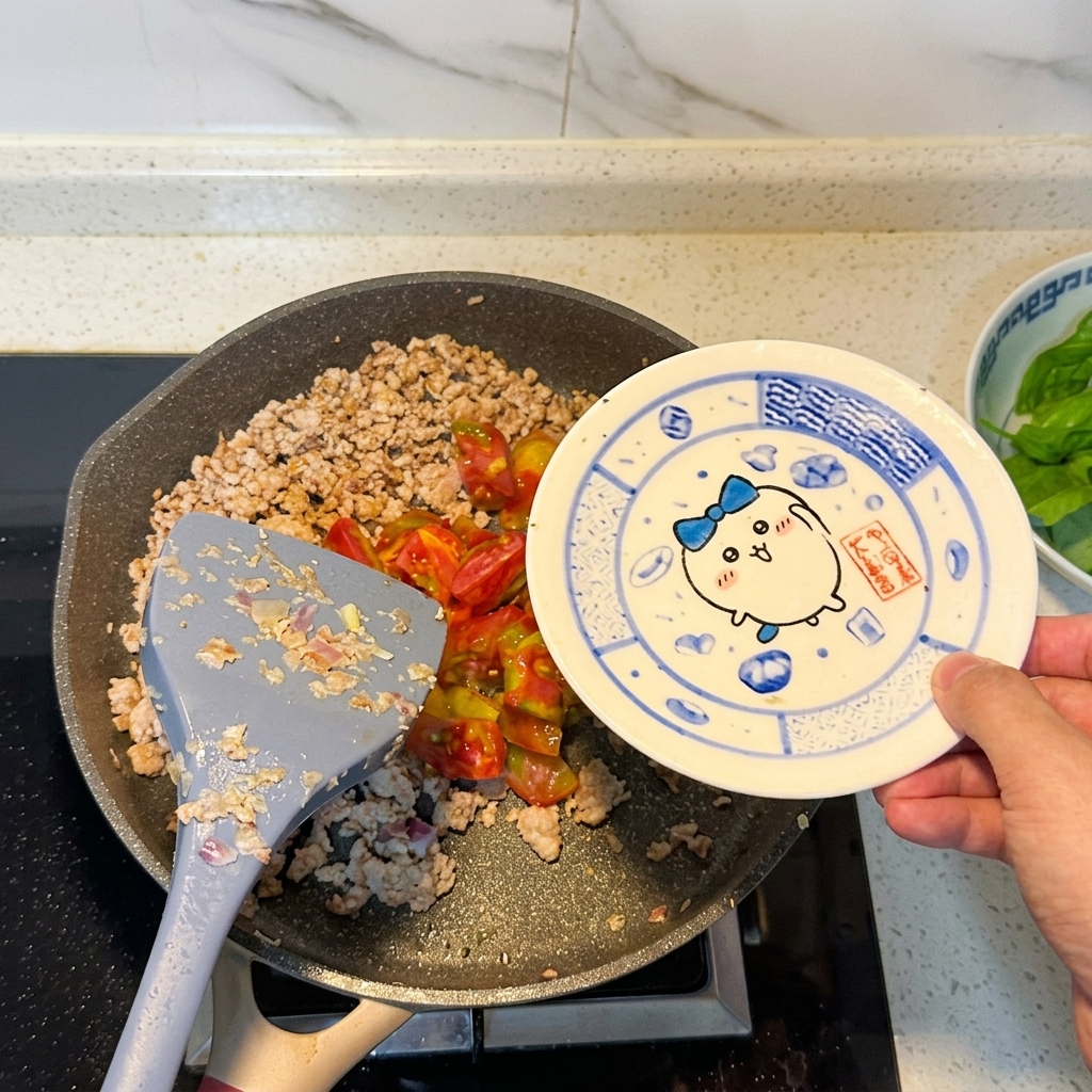 Chopped tomatoes being added to the pan of browned meat.