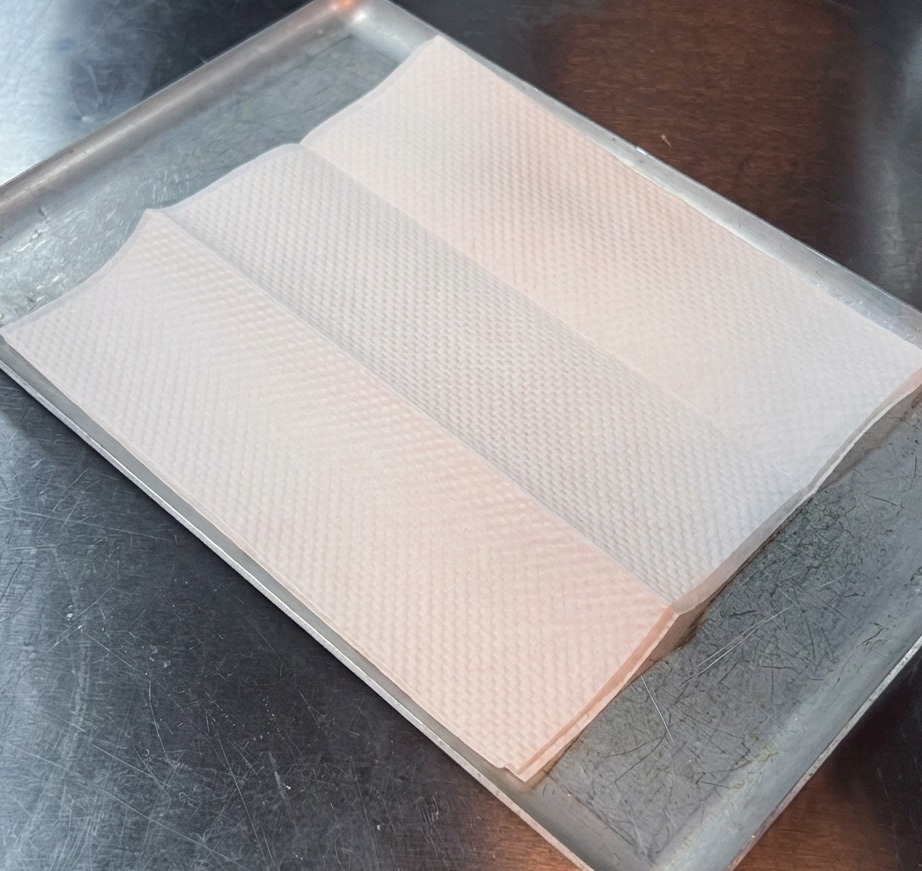 A close-up of a crispy, golden-brown fried steak resting on a clean white paper towel to drain.