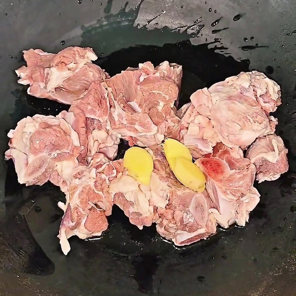Beef ribs simmering in a pot with ginger slices and cooking wine during the blanching process.