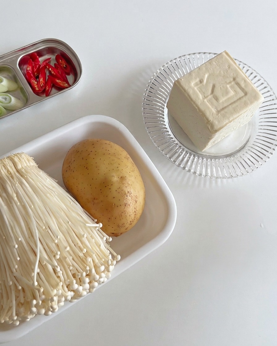 Thick, neatly sliced blocks of white firm tofu arranged on a wooden board ready for cooking.