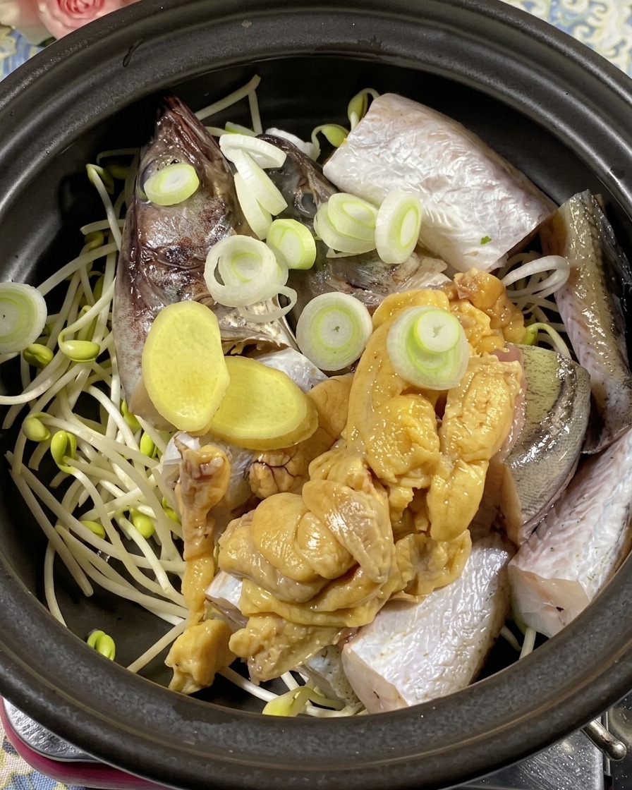A top-down view of the clay pot being filled with green scallion rings, onion wedges, and vibrant red and green chili slices.
