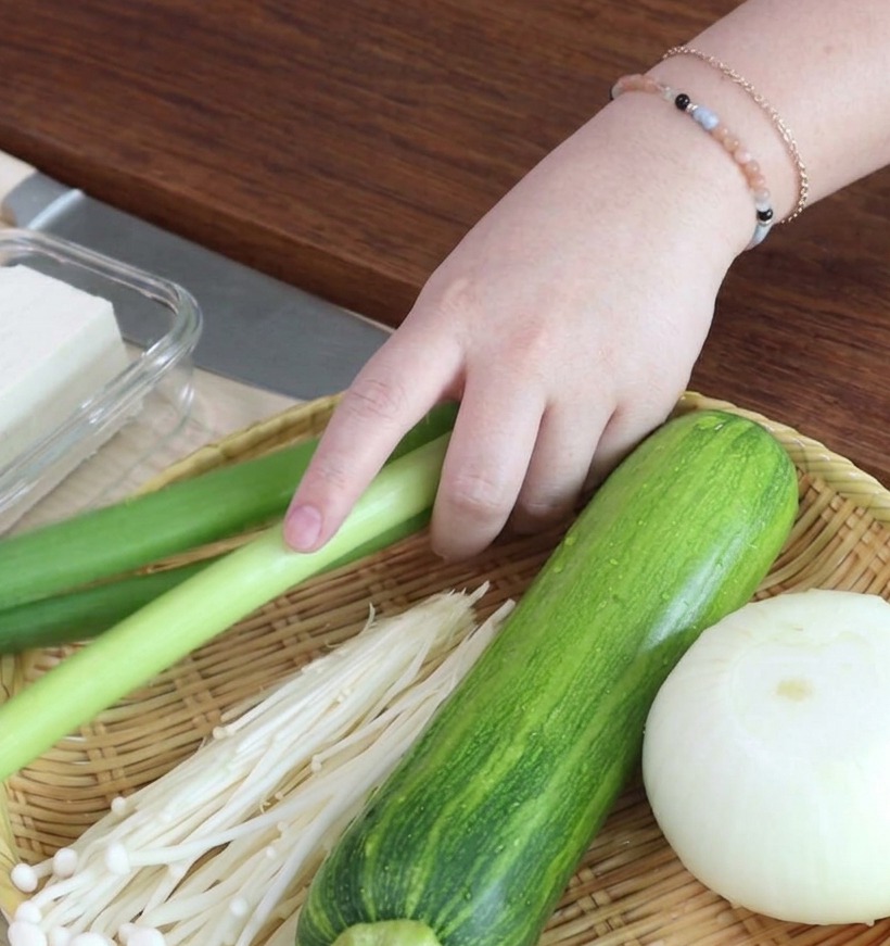 Finely chopped green onion rings neatly arranged on a wooden cutting board.
