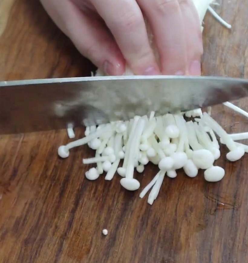 Sections of trimmed enoki mushrooms ready to be added to the stew.