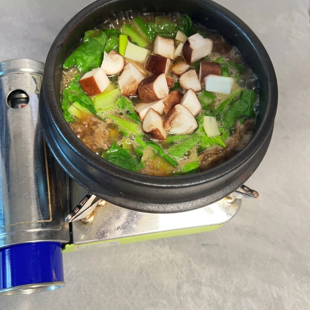 Diced shiitake mushrooms scattered into the bubbling Doenjang-jjigae.