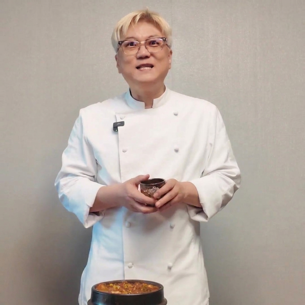 A concentrated piece of dark, aged fermented soybean paste being added to the bubbling stew.