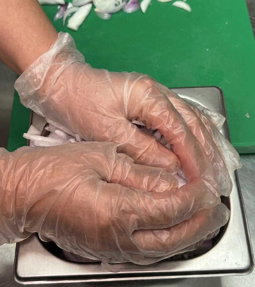 Oil being poured onto a heated metal griddle surface.