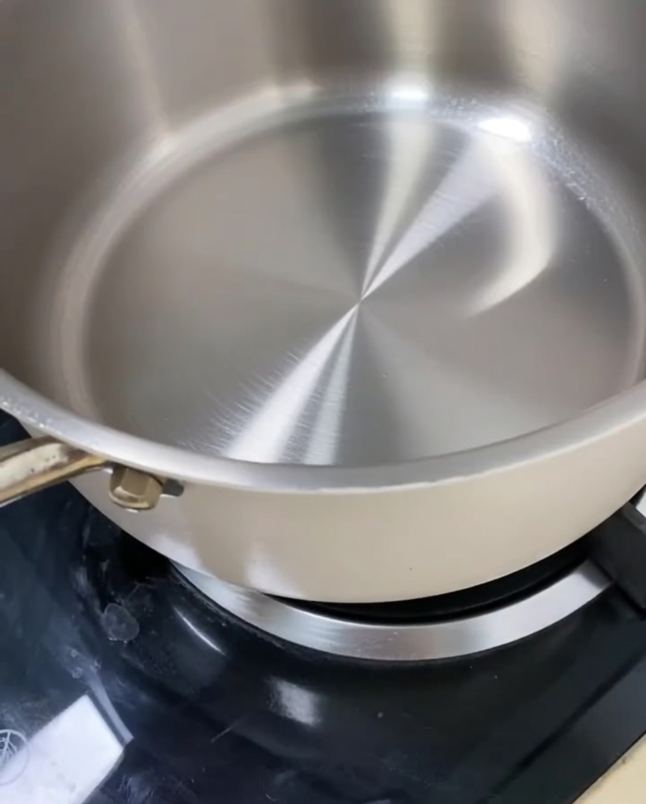 Rock sugar and white granulated sugar slowly melting in a pan to create a caramel base.