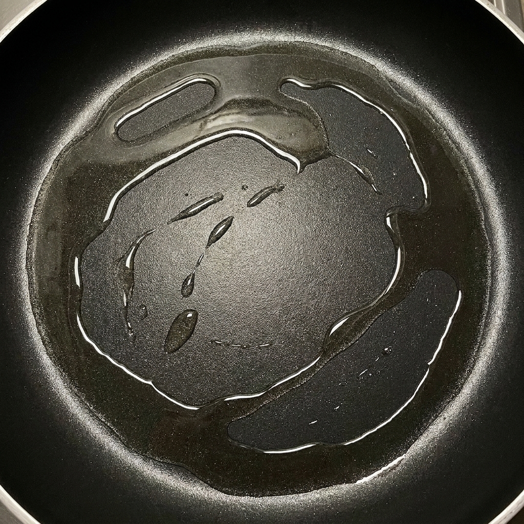 Crispy browned bacon strips sitting in a pan with rendered golden fat.