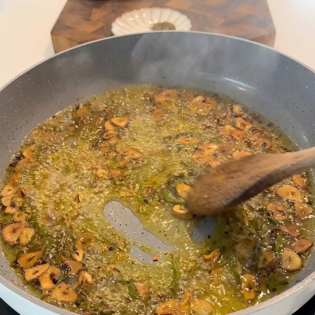 Fresh lemon juice being squeezed into the skillet with sizzling garlic and herbs.