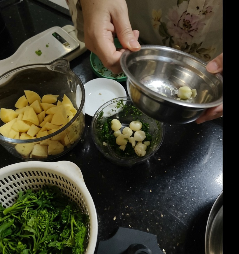 Peeled garlic cloves sitting inside a clear manual food processor bowl.